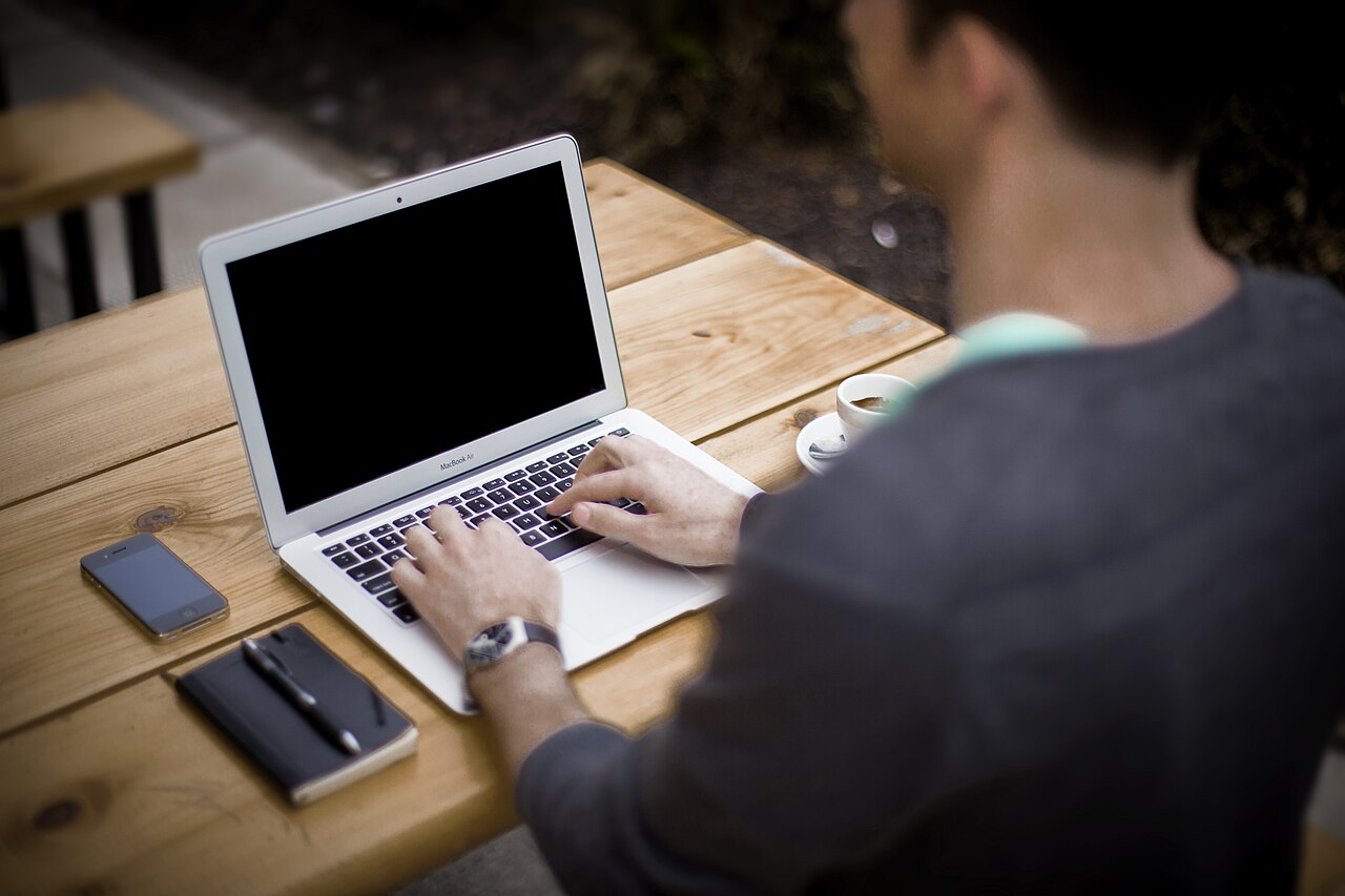 A person working on a laptop outdoors, away from a typical office