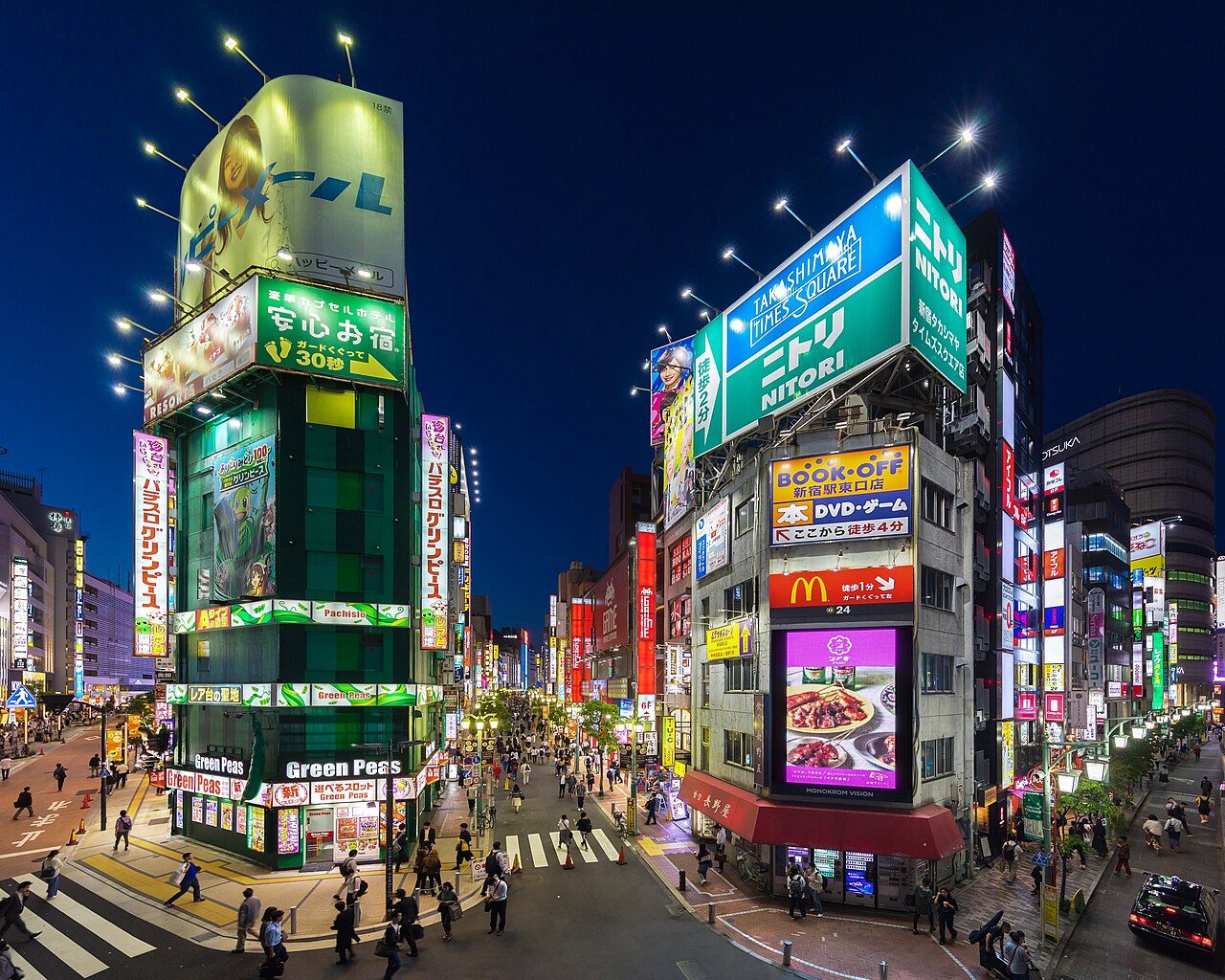 Neon signs lighting up buildings in Shinjuku, Tokyo at dusk